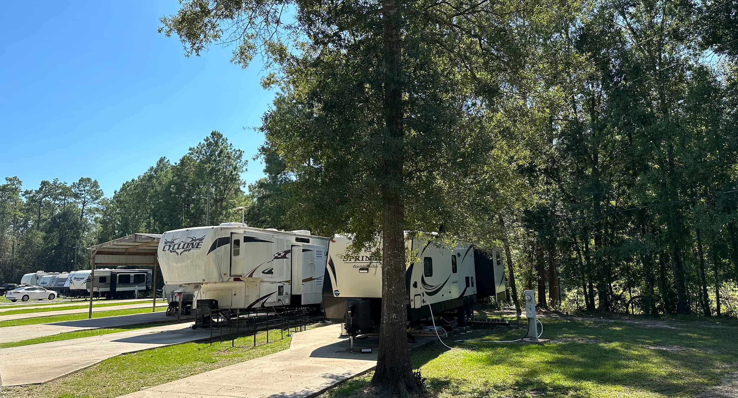Trees, concrete pads, and RVs at Texas Star RV Community.